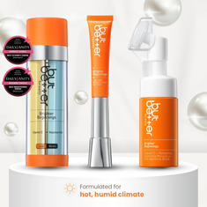 Collection of skincare products with orange and white packaging on a light gray background